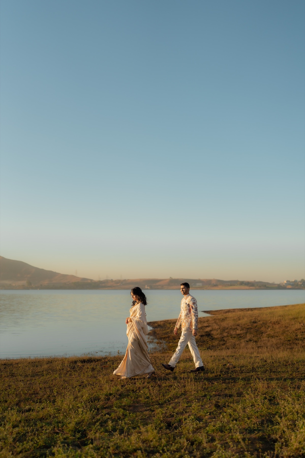 Wedding couple walking beside a lake